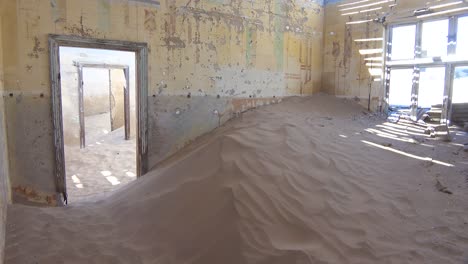 La-Arena-Llena-Un-Edificio-Abandonado-En-La-Ciudad-Fantasma-De-La-Minería-De-Gemas-De-Kolmanskop,-Namibia