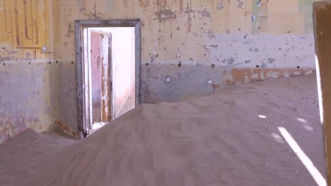 Sand-blows-through-an-abandoned-building-in-the-gem-mining-ghost-town-of-Kolmanskop-Namibia-1
