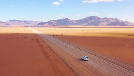 High-vista-aérea-over-a-Toyota-safari-vehicle-heading-across-the-flat-barren-Namib-Desert-in-Namibia-4