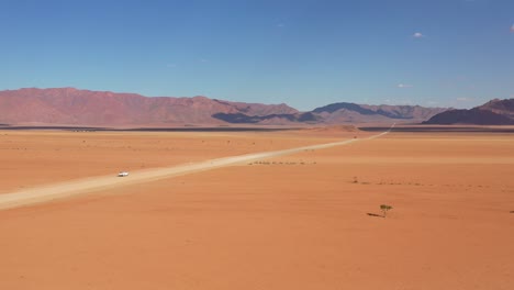 High-aerial-over-a-Toyota-safari-vehicle-heading-across-the-flat-barren-Namib-Desert-in-Namibia-5