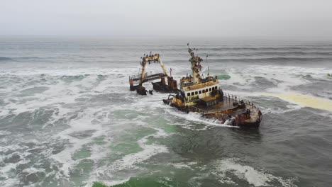 Dramatic-aerial-over-a-spooky-shipwreck-grounded-fishing-trawler-along-the-Skeleton-Coast-of-Namibia
