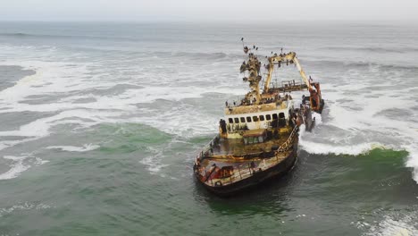 Dramatische-Luftaufnahmen-über-Einem-Gruseligen-Schiffswrack,-Das-An-Der-Skelettküste-Namibias-Gestrandet-Ist