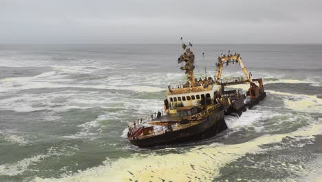 Dramatische-Luftaufnahme-über-Einem-Gruseligen-Schiffswrack,-Das-An-Der-Skelettküste-Namibias-Geerdet-Ist-3