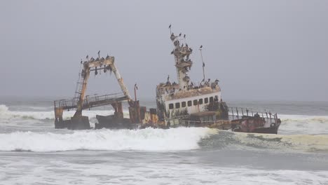 A-spooky-shipwreck-grounded-fishing-trawler-sits-in-Atlantic-waves-along-the-Skeleton-Coast-of-Namibia