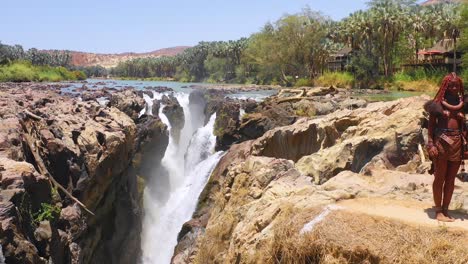 Aerial-reveals-two-Himba-tribal-women-girls-in-front-of-Epupa-waterfalls-on-the-Angola-Namibia-border-Africa