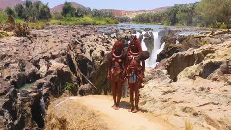 Aerial-reveals-two-Himba-tribal-women-girls-in-front-of-Epupa-waterfalls-on-the-Angola-Namibia-border-Africa-1