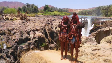 Aerial-reveals-two-Himba-tribal-women-girls-in-front-of-Epupa-waterfalls-on-the-Angola-Namibia-border-Africa-2