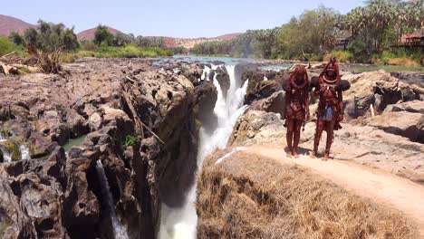Dos-Mujeres-Tribales-Himba-En-Traje-Completo-Bailan-Y-Se-Ríen-De-Epupa-Falls,-Namibia