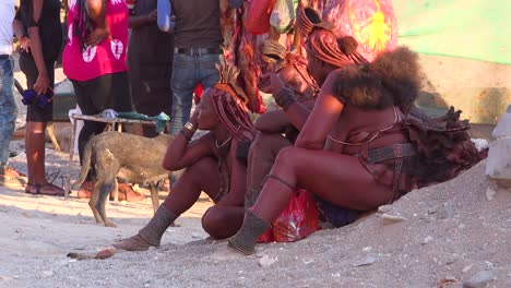 Drei-Himba-Stammesfrauen-Sitzen-An-Der-Straße-In-Der-Marktstadt-Opuwo,-Namibia,-Mit-Erstaunlichen-Geflochtenen,-Schlammgetränkten-und-Dreadlock-Frisuren