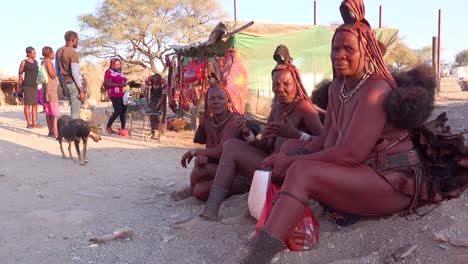 Drei-Himba-Stammesfrauen-Sitzen-An-Der-Straße-In-Der-Marktstadt-Opuwo,-Namibia-Mit-Erstaunlichen-Geflochtenen,-Schlammgetränkten-Und-Dreadlock-Frisuren-1