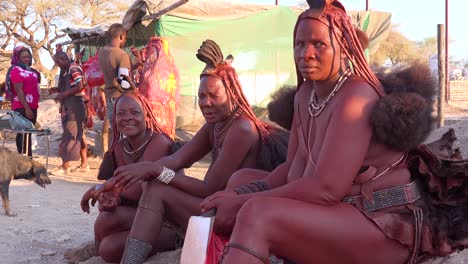 Drei-Himba-Stammesfrauen-Sitzen-An-Der-Straße-In-Der-Marktstadt-Opuwo,-Namibia-Mit-Erstaunlichen-Geflochtenen,-Schlammgetränkten-Und-Dreadlock-Frisuren-2
