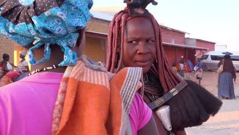 Eine-Himba-Stammesfrau-Zeigt-Ihre-Geflochtene,-Schlammverkrustete-Dreadlock-Frisur-Auf-Einem-Markt-In-Opuwo,-Namibia