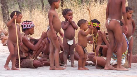 African-San-bushmen-women-children-and-tribal-natives-sit-in-a-circle-chanting-singing-and-clapping-in-a-small-village-in-Namibia-2