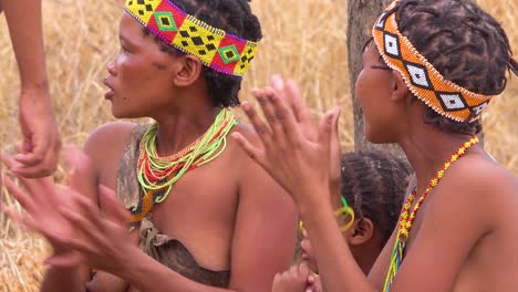 African-San-bushmen-women-niños-and-tribal-natives-sit-in-a-circle-chanting-singing-and-clapping-in-a-small-village-in-Namibia-4