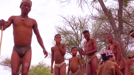 Afrikanische-San-Buschmänner-Frauen-Kinder-Und-Stammes-Eingeborene-Sitzen-In-Einem-Kreis-Singen-Und-Klatschen-In-Einem-Kleinen-Dorf-In-Namibia-5