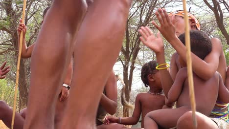 Afrikanische-San-Buschmänner-Frauen-Kinder-Und-Stammes-Eingeborene-Sitzen-In-Einem-Kreis-Singen-Und-Klatschen-In-Einem-Kleinen-Dorf-In-Namibia-8