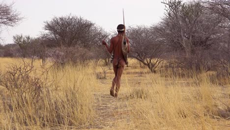 Ein-San-Tribal-Buschmann-Jäger-In-Namibia-Afrika-Geht-Leise,-Schnüffelt-Die-Luft-Und-Probiert-Den-Boden-Für-Die-Windrichtung-Auf-Der-Jagd-Nach-Beute