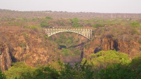 Un-Tren-De-Pasajeros-A-Vapor-Cruza-Un-Puente-Cerca-De-Las-Cataratas-Victoria-Zimbawbwe-O-Zambia-África
