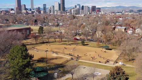 Great-aerial-over-a-dog-park-and-pet-owners-to-reveal-the-downtown-skyline-of-Denver-Colorado