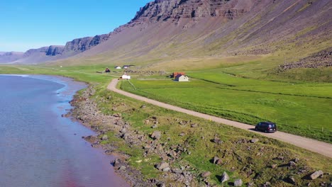 Aerial-over-a-black-van-traveling-on-a-dirt-road-in-Iceland-near-Raudisandur-Beach-in-the-Northwest-Fjords-5