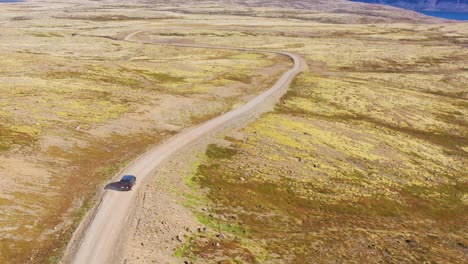 Aerial-over-a-black-camper-van-traveling-on-a-dirt-road-in-Iceland-in-the-Northwest-Fjords-1