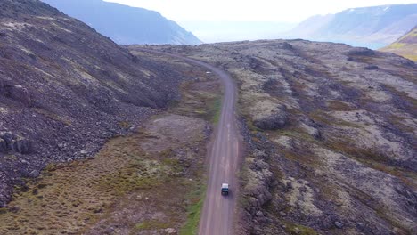 Elevación-De-La-Antena-Sobre-Una-Caravana-Negra-Viajando-Por-Un-Camino-De-Tierra-En-Islandia-En-Los-Fiordos-Del-Noroeste-1