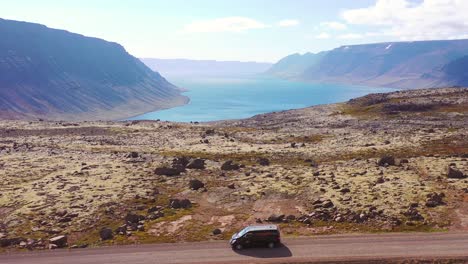 Aerial-over-a-black-camper-van-traveling-on-a-dirt-road-in-Iceland-in-the-Northwest-Fjords-2