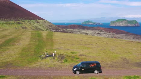Aerial-over-a-black-camper-van-traveling-on-a-dirt-road-in-Iceland-in-the-Westmann-islands-2