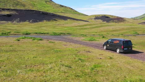 Aerial-over-a-black-camper-van-traveling-on-a-dirt-road-in-Iceland-in-the-Westmann-islands-3