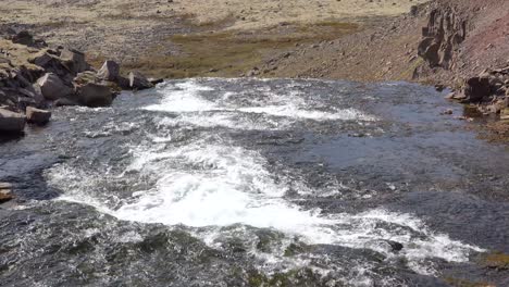 Tilt-up-of-wide-river-flowing-out-into-the-vast-fjords-of-the-Westfjords-of-Iceland