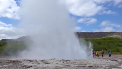 Strokkur-Géiser-Entra-En-Erupción-En-Cámara-Lenta-Frente-A-Los-Turistas-En-Islandia