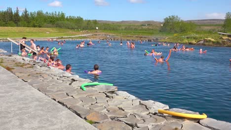 Tourists-and-Icelanders-enjoy-a-bath-in-a-hot-water-geothermal-spring-in-iceland-at-Fludir-Secret-Lagoon-1