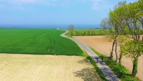 Beautiful-aerial-of-a-French-couple-riding-bicycles-through-the-green-countrside-of-Normandy-France-1