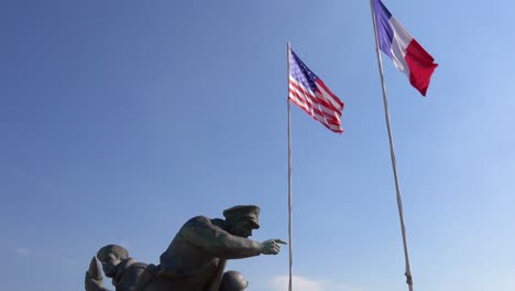 Tilt-from-American-and-French-flags-to-World-War-Two-memorial-on-Utah-Beach-Normady-France