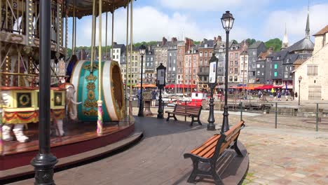 A-merry-go-round-turns-with-the-French-city-of-Honfleur-in-background