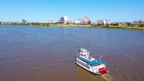 Good-aerial-of-a-paddlewheel-steamboat-riverboat-moving-up-the-Mississippi-River-with-Memphis-Tennessee-in-the-background