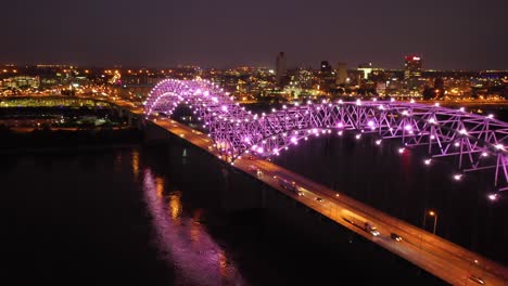 Good-rising-evening-night-aerial-of-Memphis-Hernando-De-Soto-Bridge-with-colorful-lights-cityscape-downtown-and-Mississippi-River