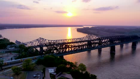 Antena-De-Los-Emblemáticos-Tres-Puentes-De-Acero-Sobre-El-Río-Mississippi-Al-Atardecer-Con-Fondo-De-Memphis,-Tennessee