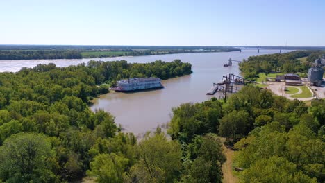Aerial-shot-of-a-paddlewheel-steamboat-luxury-cruise-ship-docked-in-a-bay-on-the-Mississippi-River