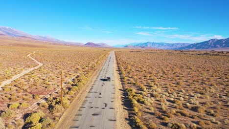 Aerial-of-a-4WD-wheel-drive-vehicle-on-a-paved-road-across-the-Owens-Valley-desert-region-suggests-remote-Eastern-Sierra-adventure-1