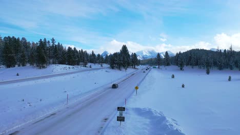 2020---vista-aérea-of-cars-conduciendo-travel-on-icy-snow-covered-montaña-road-in-the-Eastern-Sierra-Nevada-montañas-near-Mammoth-California-1