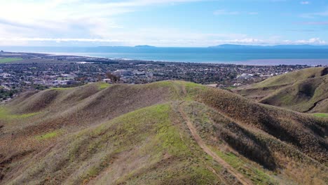 2020---aerial-over-the-pacific-coastal-green-hills-and-mountains-behind-Ventura-California-including-suburban-homes-and-neighborhoods