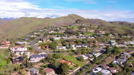 2020---aerial-over-the-pacific-coastal-green-hills-and-mountains-behind-Ventura-California-including-suburban-homes-and-neighborhoods-2