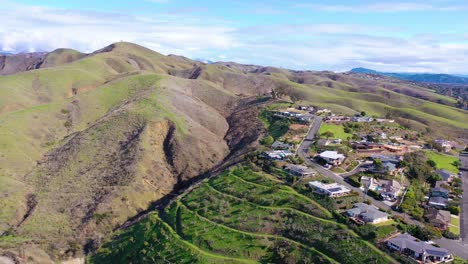 2020---aerial-over-the-pacific-coastal-green-hills-and-mountains-behind-Ventura-California-including-suburban-homes-and-neighborhoods-4