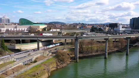 Nice-aerial-of-Amtrak-passenger-train-arriving-in-Portland-Oregon-with-light-rail-above-and-Moda-Center-background