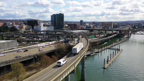 High-angle-aerial-shot-of-freeway-traffic-Amtrak-train-and-Willamette-River-in-Portland-Oregon