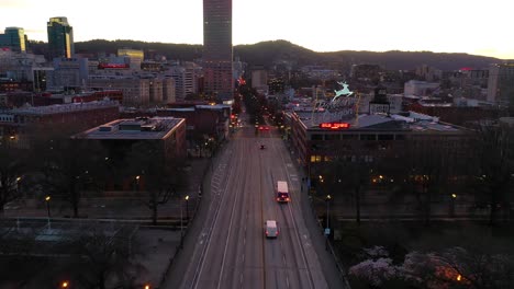 Moody-aerial-past-Portland-Oregon-stag-deer-sign-and-downtown-old-town-cityscape-and-business-district-at-sunset-or-dusk