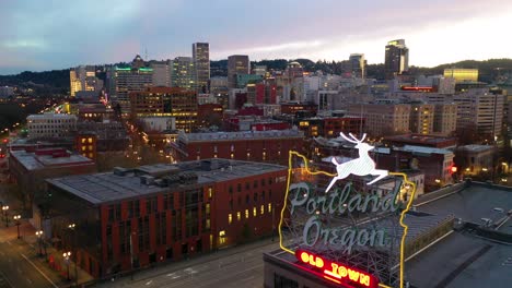 Aerial-around-Portland-Oregon-stag-deer-sign-and-downtown-old-town-cityscape-and-business-district-at-sunset-or-dusk-1