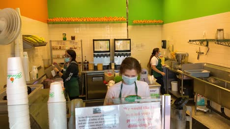 2020---food-and-beverage-industry-workers-working-hard-at-a-juice-bar-during-the-Coronavirus-Covid-19