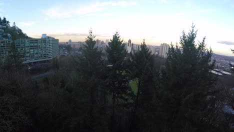 A-majestic-rising-shot-over-pine-trees-reveals-the-city-skyline-of-Portland-Oregon
